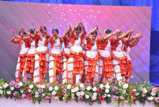 Students performing a traditional dance on stage during a cultural event